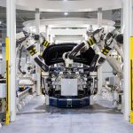 Robôs industriais montam um automóvel em uma fábrica moderna.