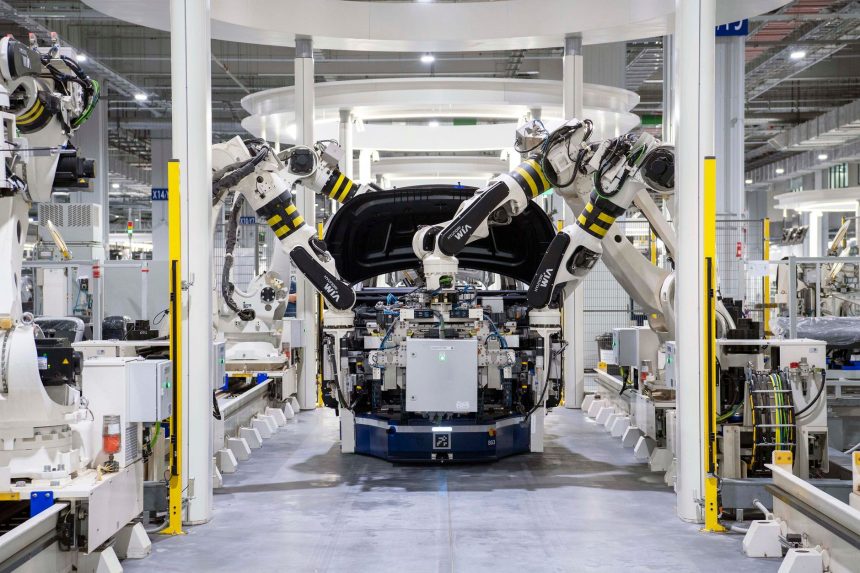 Robôs industriais montam um automóvel em uma fábrica moderna.